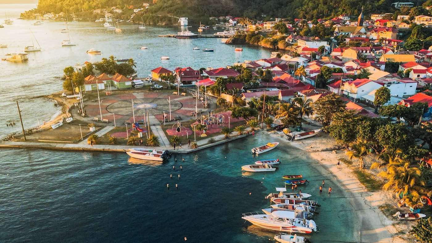 Baie des Saintes au soleil couchant, voiliers au mouillage et toits rouges du bourg