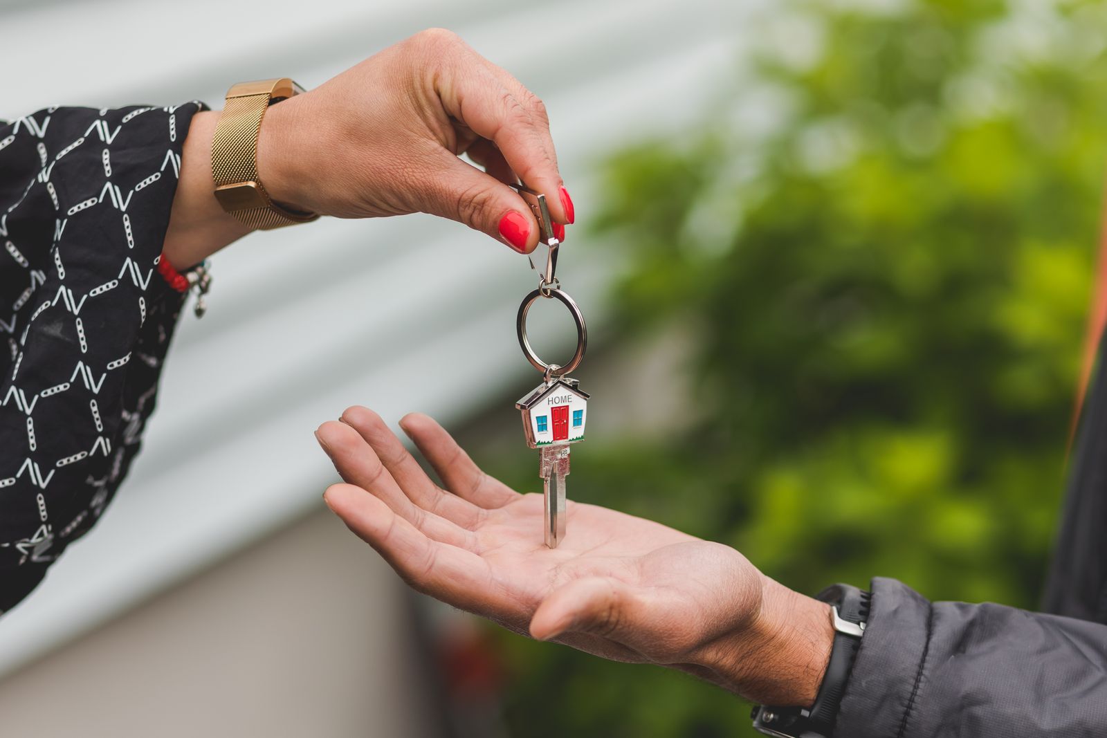 Remise des clés d’une location de main à main devant un jardin