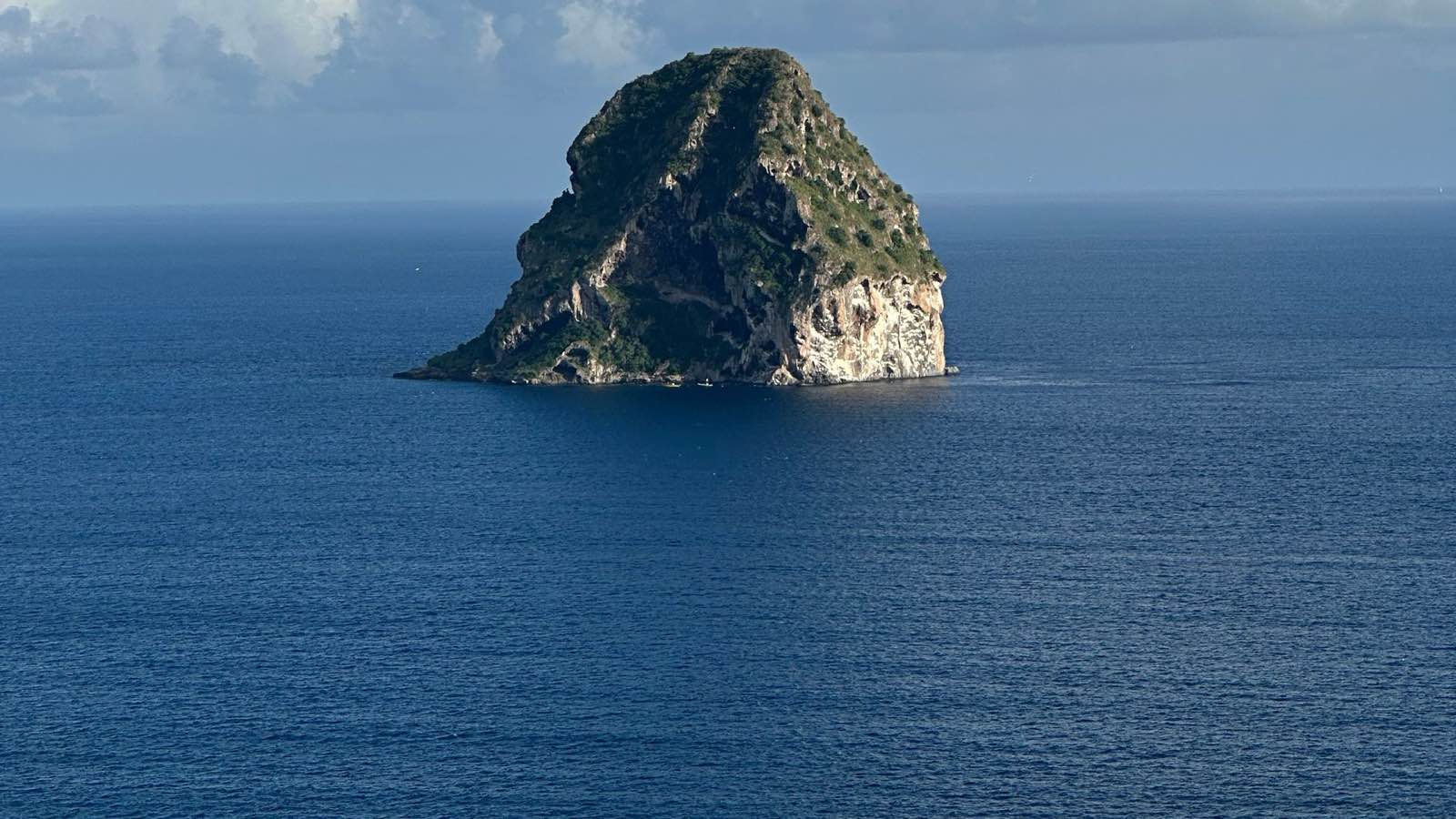 Le Rocher du Diamant émergeant seul de la mer des Caraïbes sous les nuages